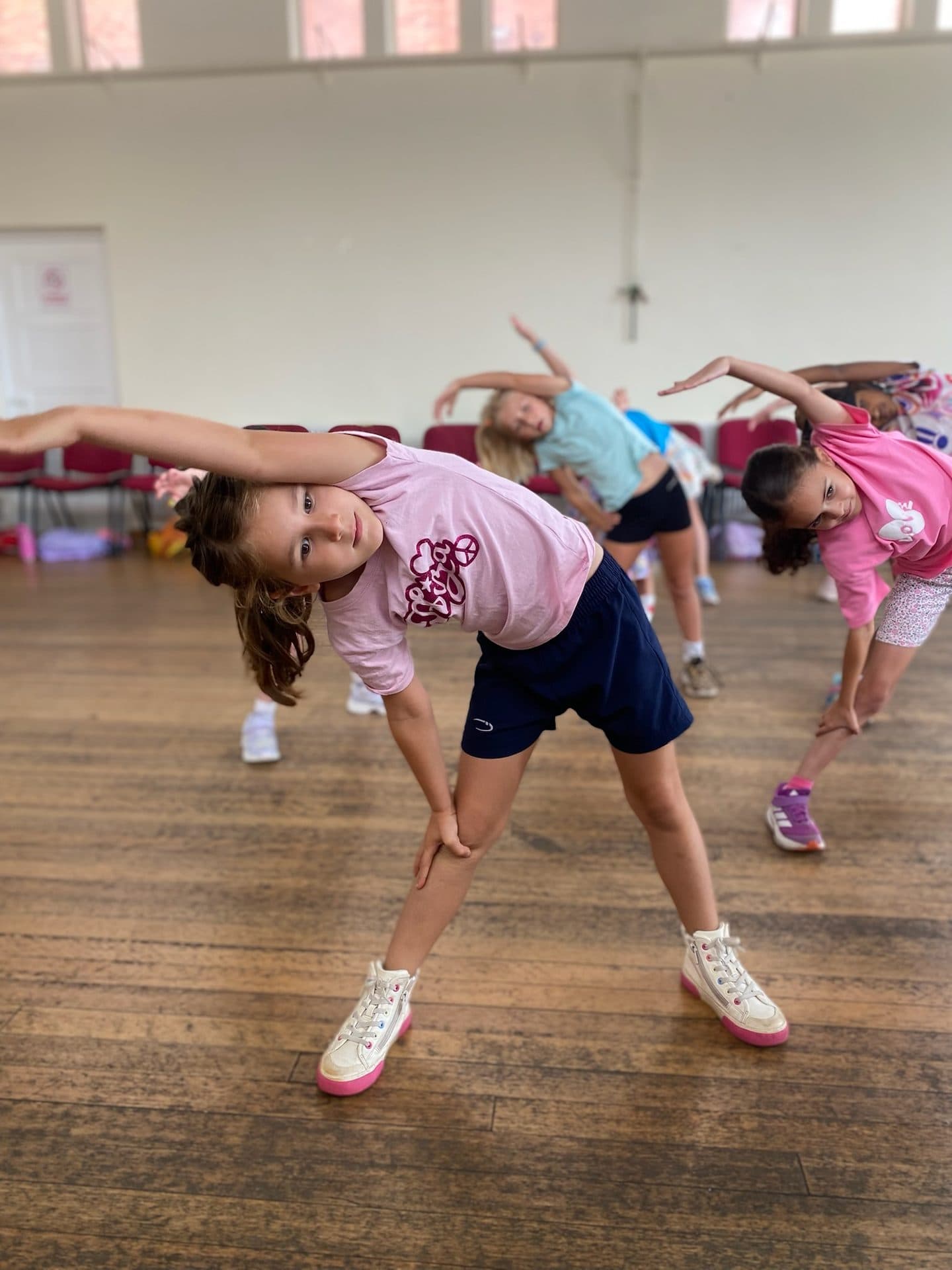 Young dancers stretching together at a Village School holiday camp